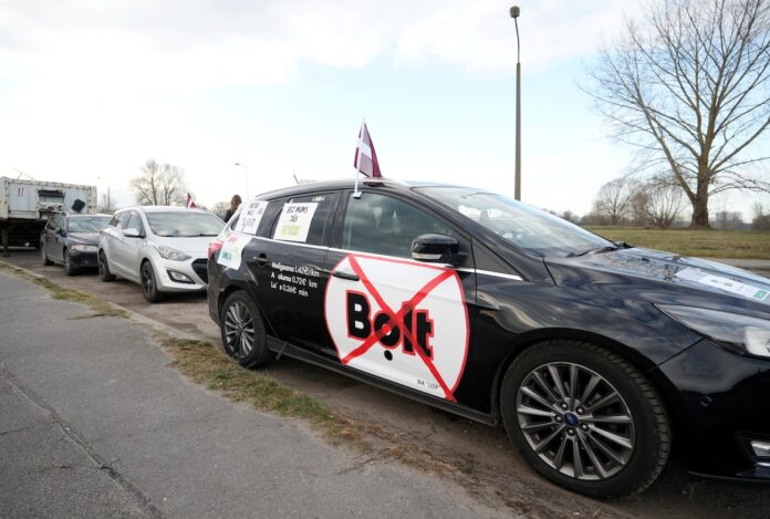 Bolt Latvija, taksometru protests, Rīga satiksmes ierobežojumi, Bolt monopols, taksisti Latvijā, Bolt komisijas, taksometru cenas, pasažieru pārvadājumi Latvijā, transporta nozare,